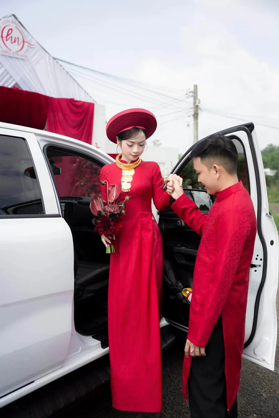 Cô dâu áo dài đỏ được chú rể nắm tay bước xuống xe