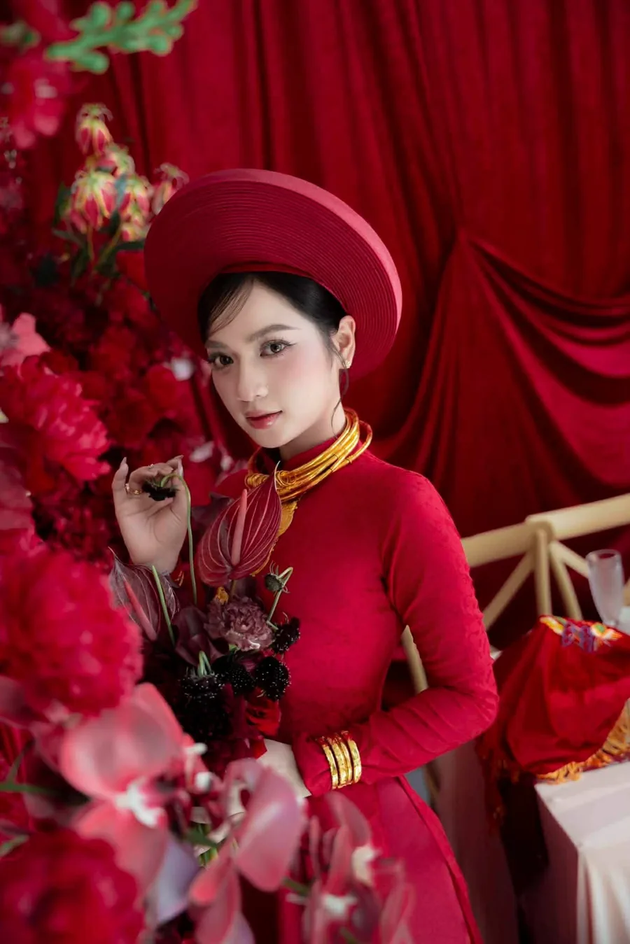 Cô dâu áo dài đỏ bên tường hoa đỏ